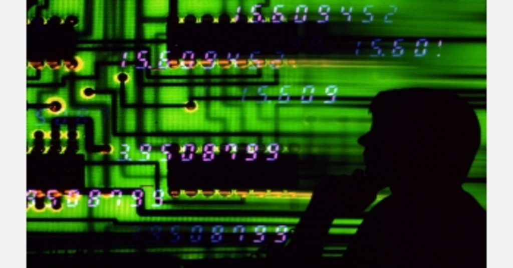 numbers and colored bars evoke an information stream while a person watches from the shadows to represent malicious insiders stealing compny data to sell on the Dark Web