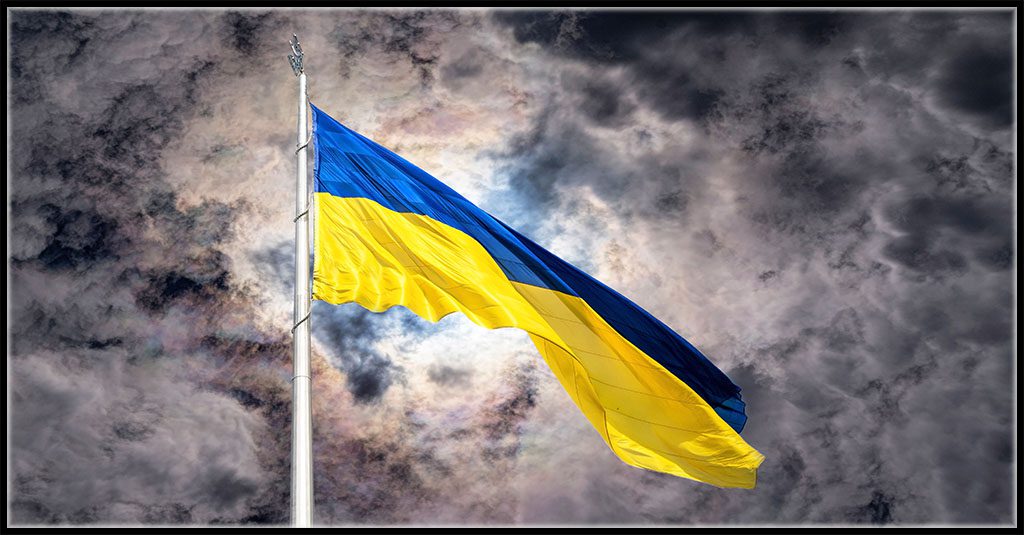 Ukraine charity phishing scams represented by the Ukrainian flag waving against storm clouds