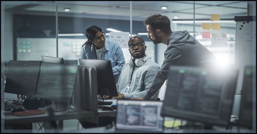 A diverse group pf It professionals collaborate at a computer workstation