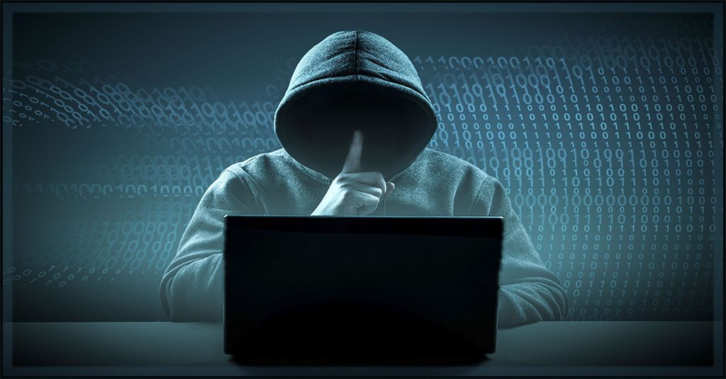 an ominously dark image of a hacker in a blue grey hoodie with the face obscured.